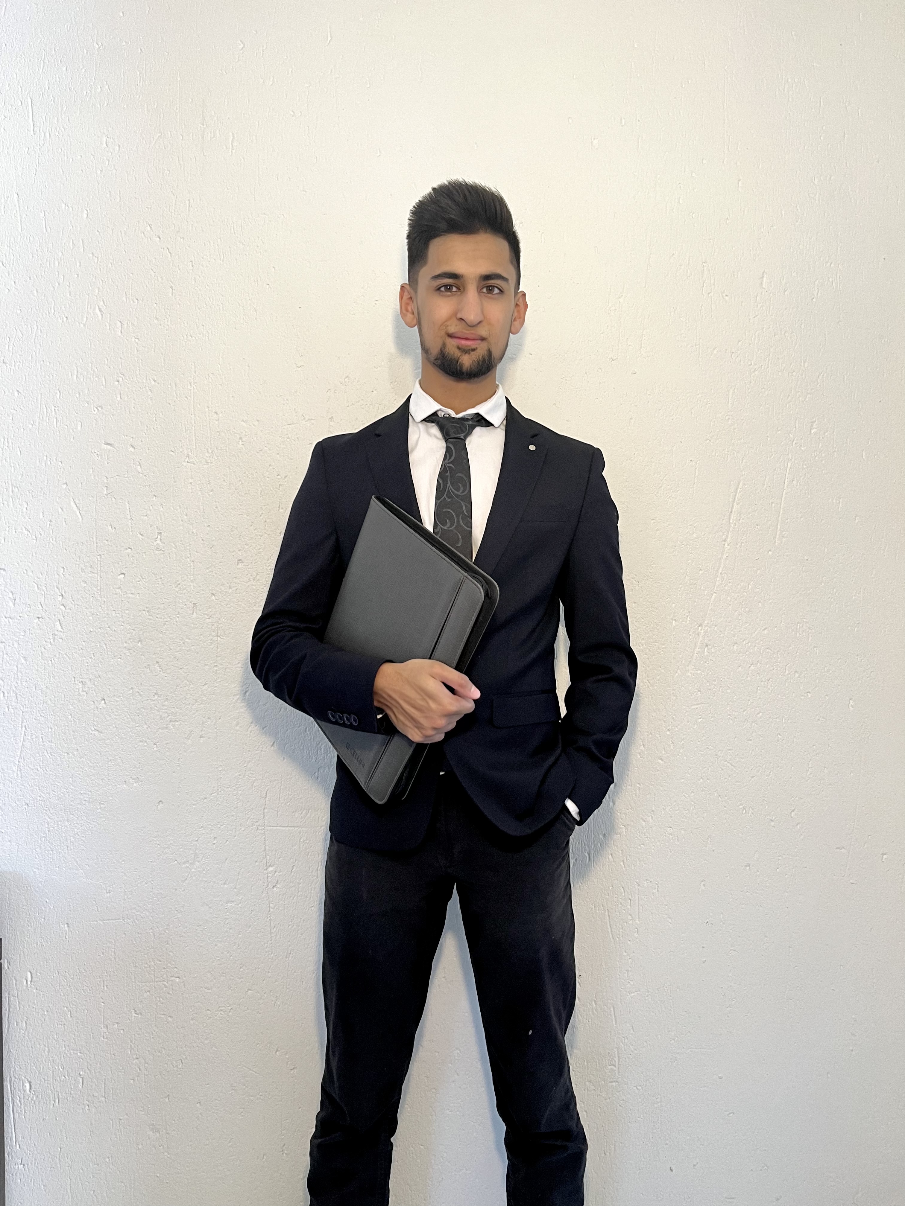 Professional headshot of Abdullah Hassan in modern office